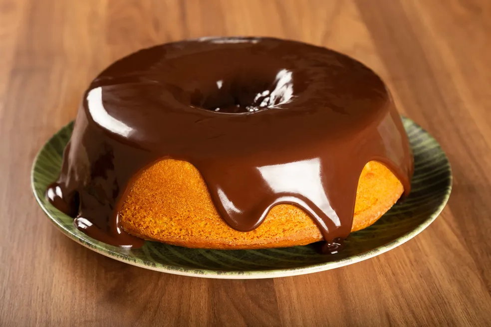 Aprenda a fazer um bolo de cenoura com calda de chocolate fofinho, prático e com ingredientes mais saudáveis. Perfeito para o lanche da tarde!